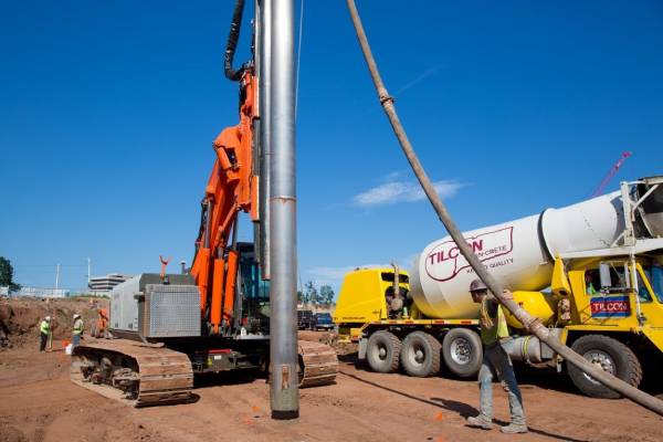 Heavy machinery drilling into the foundation of a construction site.
